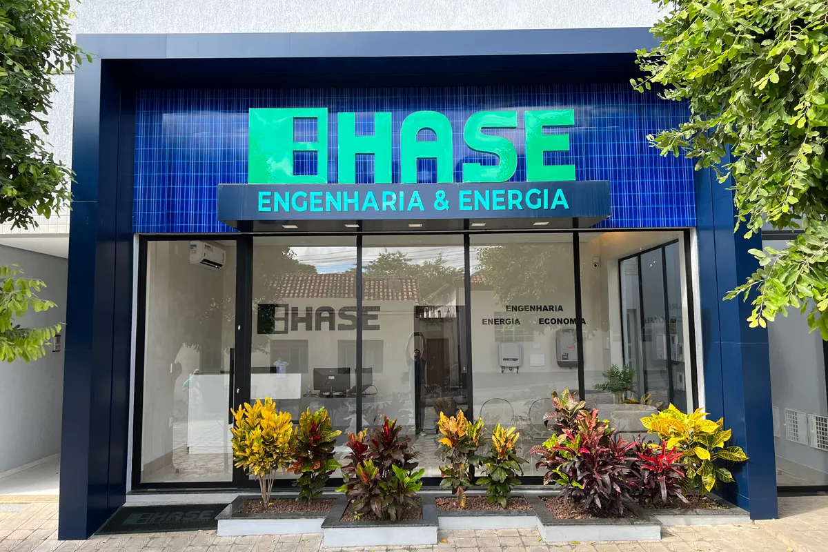 Fachada da unidade HASE em Salinas, MG: letreiro HASE Engenharia & Energia sobre painel azul e vitrine de vidro.