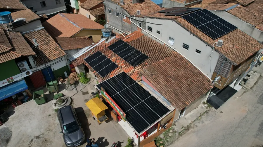 Vista aerea de casa de esquina em Arraial com dois conjuntos de paineis solares no telhado