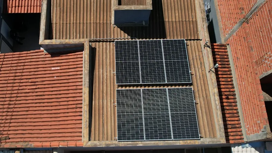 Vista aerea de casa em Salinas com dois conjuntos de paineis solares sobre telhado de telha ceramica