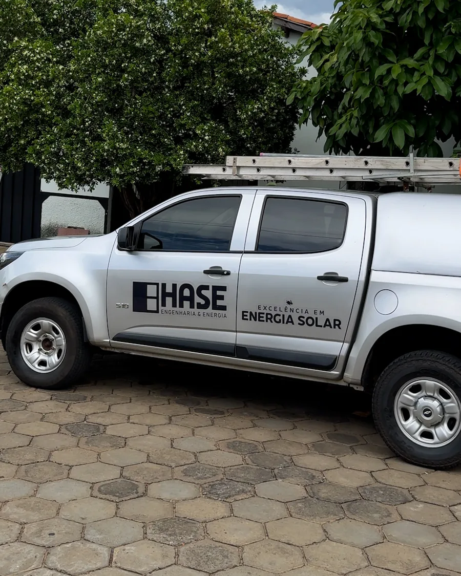Caminhonete da HASE estacionada em frente ao imóvel, com escada no rack, no dia da visita técnica.